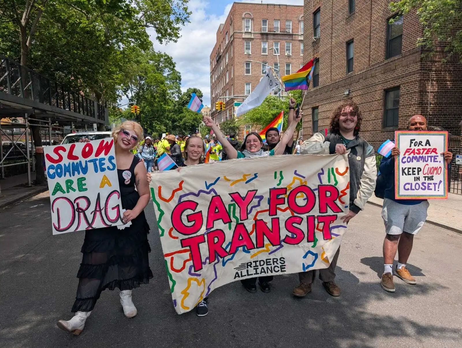 Riders Alliance in the Queens Pride Parade with a sign that says Gay for Transit